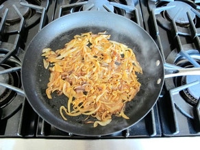 Sliced, caramelized onions in a skillet.