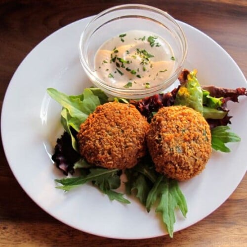 Overhead shot of Spicy Panko Chickpea Patties served on a white round plate on top of a wooden table