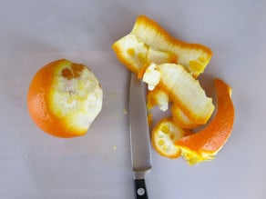 Slicing peel and pith off an orange.