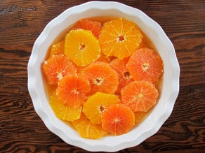 Sliced oranges soaking in simple syrup.