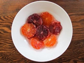 Sliced blood oranges in a bowl.