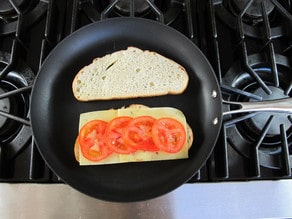 Tomato slices on sourdough bread in a skillet.