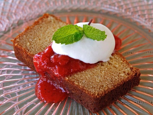Slice of Almond Ricotta Pound Cake drizzled with strawberry sauce and mint leaves