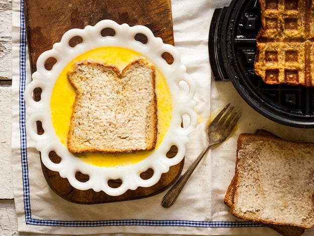 Dipping slice of bread in egg mixture.