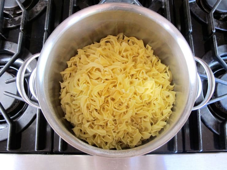 Cooked egg noodles in a stockpot.