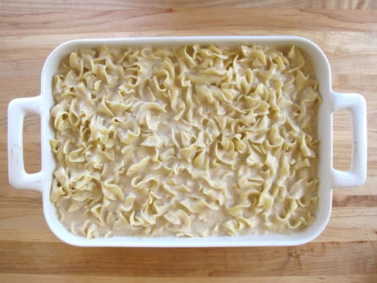 Coated noodles in a baking dish.
