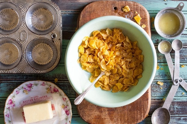 Stirring melted butter into cornflakes.