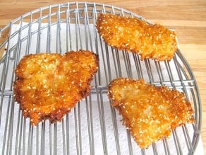Fried fish fillets draining on a rack.