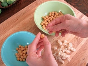 Popping chickpeas out of their skins.