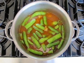 Sliced fava beans added to stockpot.