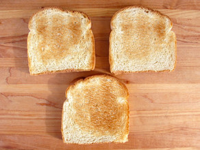 Three slices of toast on a cutting board.