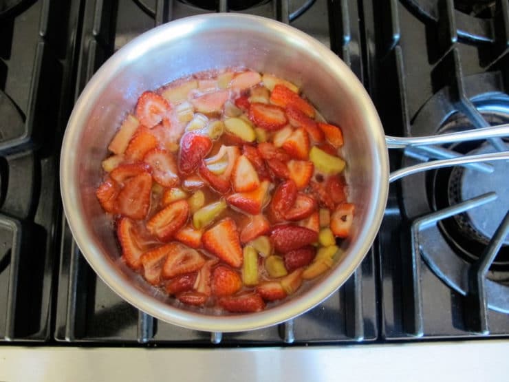 Strawberries and rhubarb simmering in a saucepan.