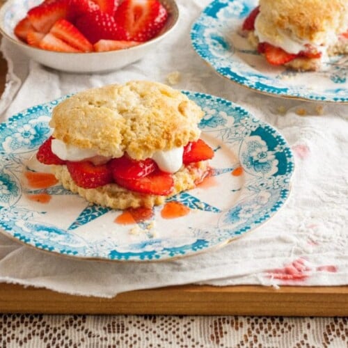 A delectable strawberry shortcake placed on a blue plate, enticingly filled with fresh strawberries and whipped cream