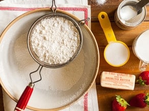 Sifting flour into a mixing bowl.