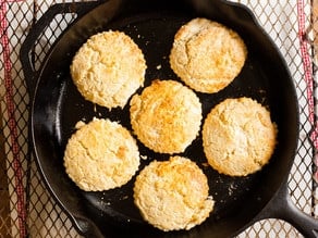Biscuits cooking in a cast iron skillet.