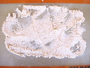 Almond pulp thinly spread on a baking sheet.