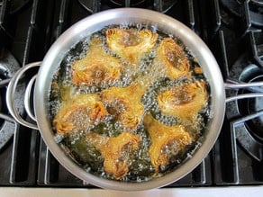 Deep-frying artichoke hearts.