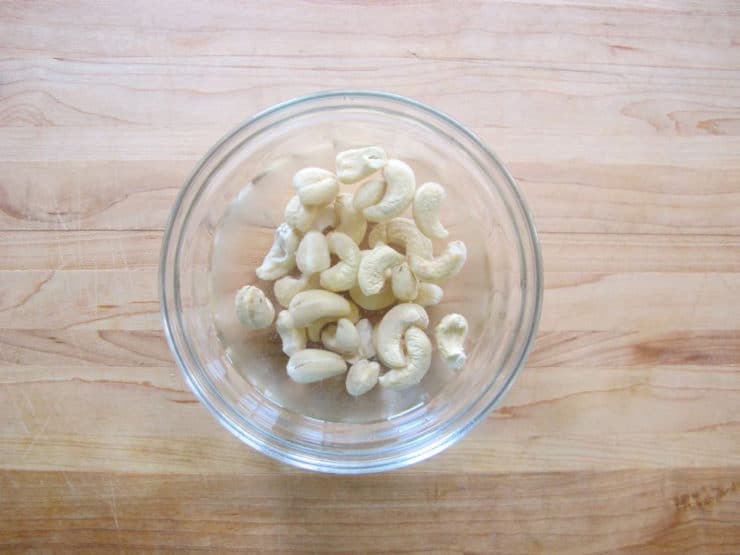 Cashews soaking in small bowl of water.