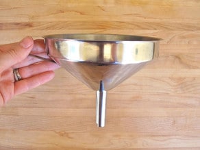 Metal funnel for making funnel cakes.