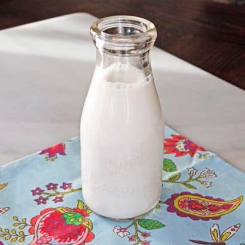 Image of a glass of Cashew Milk resting on a tablecloth