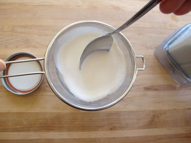 Straining all milk through cashew pulp.