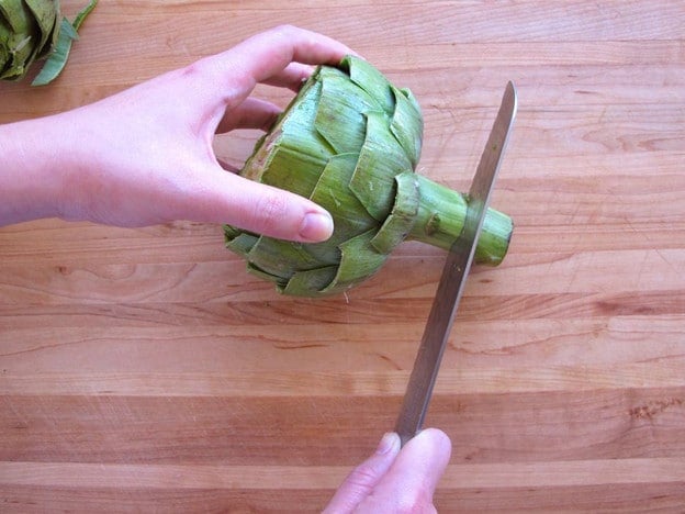 Slicing off an artichoke stem.