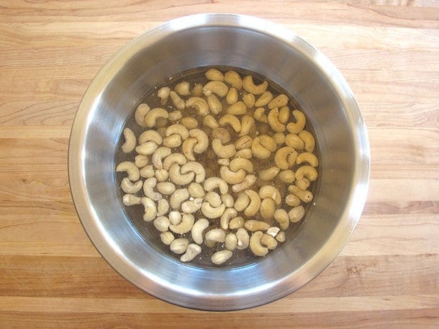 Cashews soaking in a bowl of water.