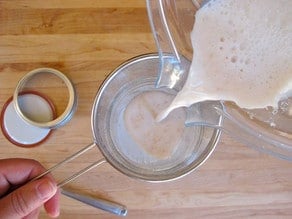 Straining almond milk.