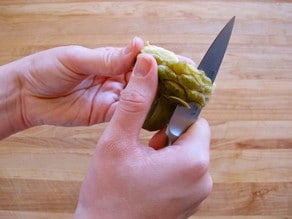 Trimming an artichoke heart with a paring knife.