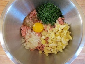 Ground turkey, egg, and spices in a mixing bowl.