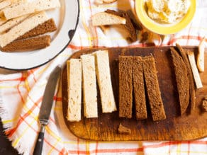 Rye bread on a cutting board sliced into long fingers.