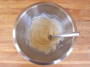 Stirring yogurt into protein powder in a mixing bowl.