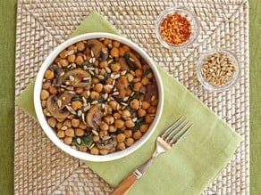 A bowl filled with chickpeas and mushrooms, part of a Chickpea, Spinach and Mushroom Sauté dish