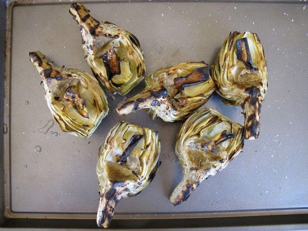 Grilled artichokes on a sheet pan.