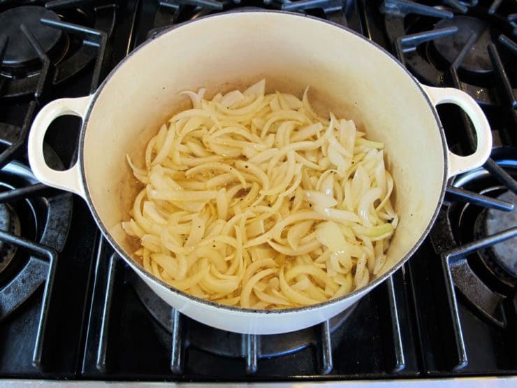 Cooking sliced onions in a Dutch oven.