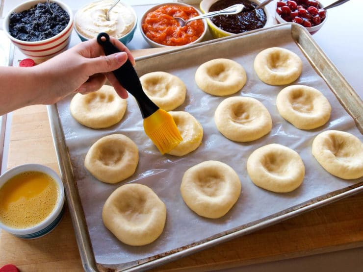 Brushing kolache with melted butter.