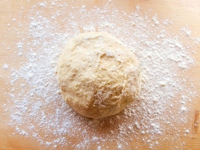 Kneading kolache dough in a mixing bowl.