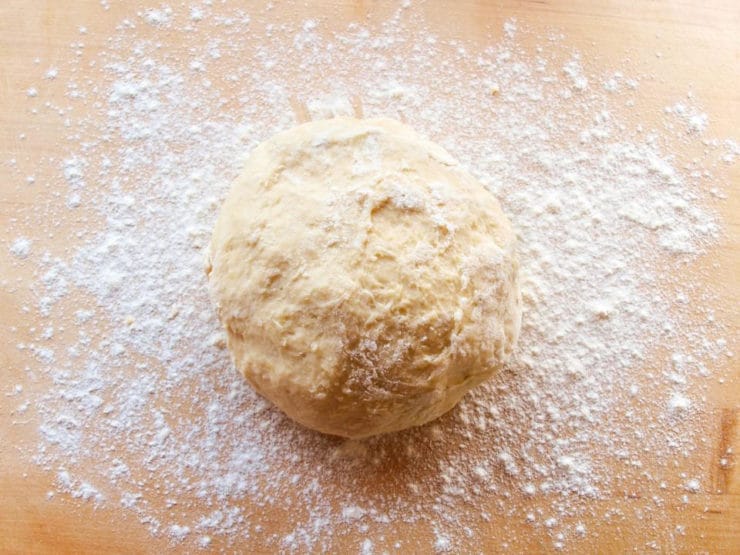 Kneading kolache dough in a mixing bowl.