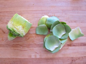 Outer leaves removed from artichoke heart.
