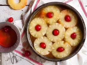 Pineapple rings and cherries lining an oven-proof skillet.