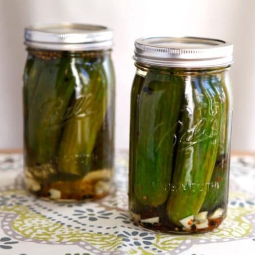 Two jars of pickles on a placemat.