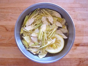 Sliced artichoke in a bowl of lemon water.