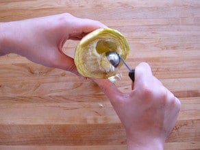 Artichoke heart being removed with a melon baller.