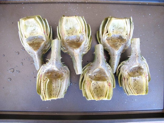 Artichoke halves on a sheet pan.