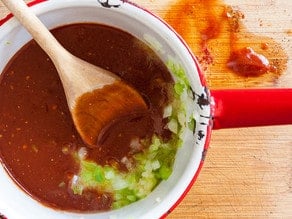 Stirring up barbecue sauce in a small pot.