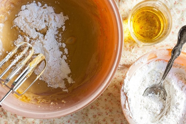 Stirring flour into wet cake batter ingredients.