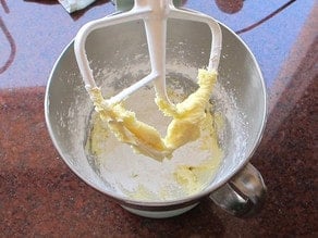 Powdered sugar added to butter in a stand mixer.