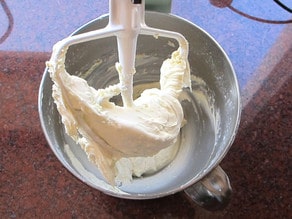 Whipping cream added to butter and sugar in a stand mixer.