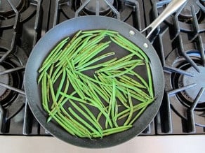 Sauteeing green beans in a skillet.