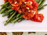Caponata Green Beans Pinterest Pin - dish of thin sautéed green beans covered in caponata sauce